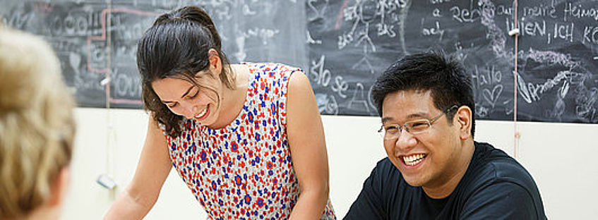 Zwei lachende Studierende bei Gruppenarbeit